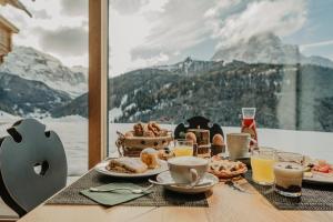 a table with breakfast food and a view of a mountain at Gutonhof in Selva di Val Gardena