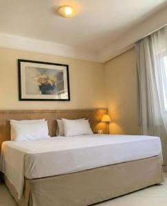 a bedroom with a large bed with white pillows at Bienal Suítes in São Paulo +31 photos