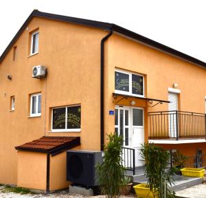 a yellow building with a tv in front of it at Apartmani Cassiopeia in Murine +19 photos