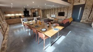 a dining room with a table and a kitchen at Létable de Boissadel in Boisset