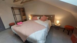 a bedroom with a large bed with pink pillows at Létable de Boissadel in Boisset