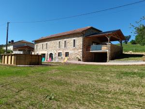 a brick building with a large yard in front of it at Létable de Boissadel in Boisset