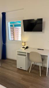 a white desk with a chair and a window at Hotel Giardino del Sole in Savona