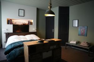 a bedroom with a bed and a table with a bowl on it at Maison PARAGONE in Bergues