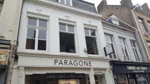 a store front with a paragoncano sign on a street at Maison PARAGONE in Bergues