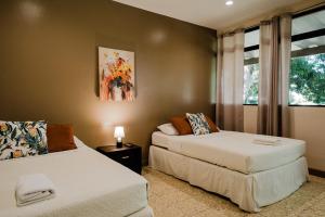 a bedroom with two beds and a window at Hotel Diriá Santa Cruz in Santa Cruz