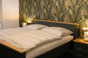 a bed in a bedroom with a wall with auliculiculiculiculiculic at Ferienappartment Sickert in Groß Särchen