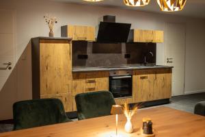 a kitchen with a table and chairs and a sink at Ferienappartment Sickert in Groß Särchen