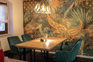 a dining room with a wooden table and green chairs at Ferienappartment Sickert in Groß Särchen