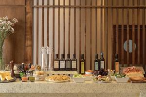 a table with bottles of wine and plates of food at NH Mendoza Cordillera in Mendoza