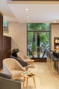 a living room with couches and chairs and a large window at NH Mendoza Cordillera in Mendoza +27 photos