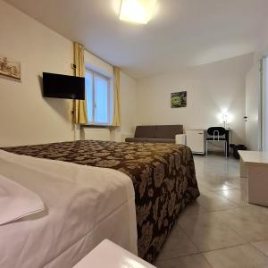 a hotel room with a bed and a couch at Hotel Giardino del Sole in Savona