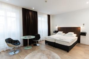 a bedroom with a bed and a table and chairs at Littke Pezsgőház in Pécs