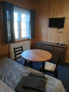 a room with a table and a bed and a desk at PENZION PARMA in Ostružná