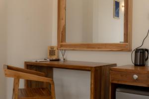 a wooden dressing table with a mirror on a wall at Orca Dickwella in Dickwella