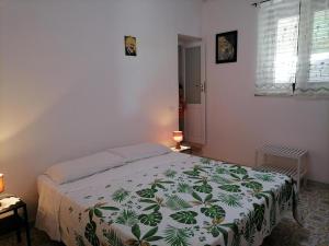 a bedroom with a bed with a green and white blanket at Casa Vacanze "Villa Angelina" in Lipari