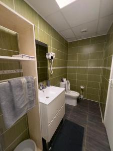 a bathroom with a white sink and a toilet at Habitations Amédée in Bouillante