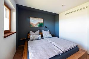 a bedroom with a bed with a blue accent wall at BergSeeMomente in Breitbrunn am Chiemsee