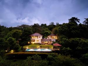 a house in the middle of a forest at night at Kandy Knightsdale Villa in Panwila