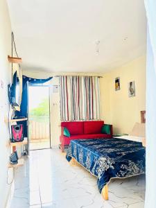 a bedroom with a bed and a red couch at Zion Homes in Taveta