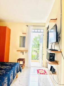 a bedroom with a bed and a tv and a window at Zion Homes in Taveta