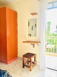 a stool in a room with a mirror and a window at Zion Homes in Taveta +11 photos