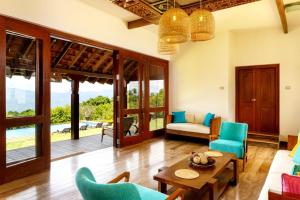 a living room with blue chairs and a table at Kandy Knightsdale Villa in Panwila