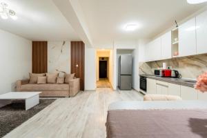 a living room with a couch and a kitchen at Fortuna Park Apartman in Sfântu-Gheorghe