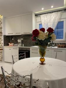 a vase of roses sitting on a table in a kitchen at LEONORA’S APARTMENT in Prinos