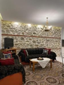 a living room with two couches and a table at LEONORA’S APARTMENT in Prinos