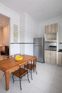 a kitchen with a wooden table with bananas on it at Apê 401 - Central, Garagem e Ar-Condicionado - 2Q in Governador Valadares