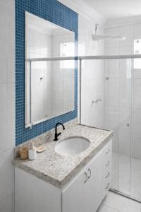 a bathroom with a sink and a shower with a mirror at Apê 401 - Central, Garagem e Ar-Condicionado - 2Q in Governador Valadares +5 photos