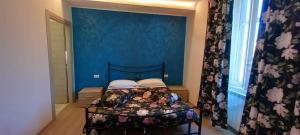 a bedroom with a bed with a blue wall at Albano Station Rooms in Pavona