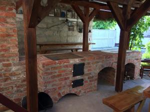an outdoor brick oven with a table and a bench at Mandulaág Vendégház in Egerszalók