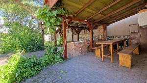 an outdoor patio with a wooden table and bench at Mandulaág Vendégház in Egerszalók