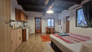 a bedroom with a bed and a kitchen with a table at Mandulaág Vendégház in Egerszalók