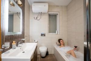 a woman sitting in a bath tub in a bathroom at The Strand Waterfront Apartment with 3 Bedrooms, 4 Bathrooms, Private Garage in Sliema