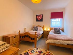 a bedroom with two twin beds and a window at Hidden Gem in a great location very near Isle of Skye in Kyle of Lochalsh +9 photos