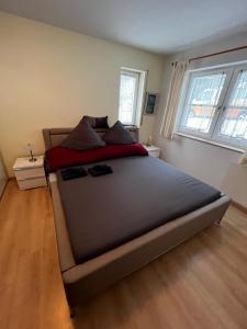 a large bed in a bedroom with two windows at Ferienwohnung Schöne Aussicht in Todtmoos