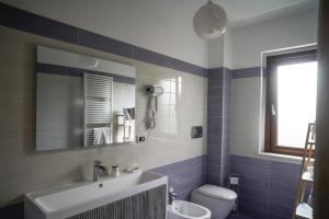 a bathroom with a sink and a toilet and a mirror at Villa Kappa - disponibili anche camere climatizzate - in LʼAquila +49 photos