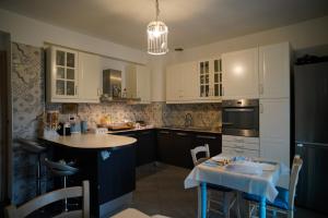 a kitchen with white cabinets and a small table with a table at Villa Kappa - disponibili anche camere climatizzate - in LʼAquila