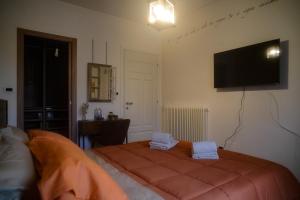 a bedroom with a bed and a flat screen tv at Villa Kappa - disponibili anche camere climatizzate - in LʼAquila