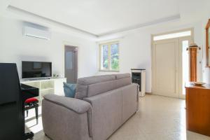 a living room with a couch and a television at Casa Saveria in Massa Lubrense