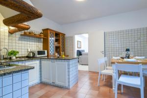 a kitchen with white cabinets and a table and chairs at Casa Saveria in Massa Lubrense