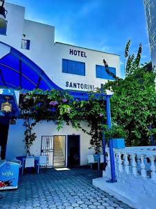a hotel with tables and chairs in front of it at Hotel Santorini Doradal in Doradal