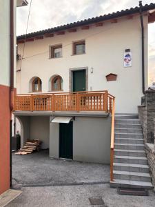 ein Haus mit einer Terrasse an der Seite in der Unterkunft Da Cinto in Paluzza