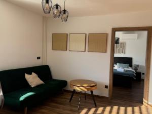 a living room with a green couch and a mirror at IQ Apartments in Prešov