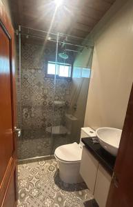 a bathroom with a shower and a toilet and a sink at Casa del abuelo Lodge in Cajamarca