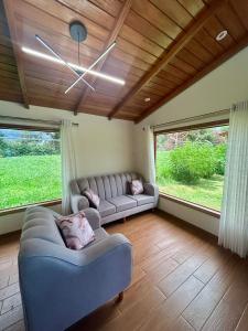 a living room with a couch and two windows at Casa del abuelo Lodge in Cajamarca