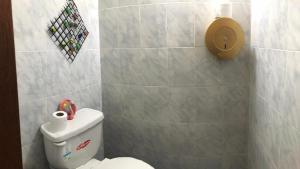 a bathroom with a toilet with a roll of toilet paper at Hospedaje las Primicias 103 in Riobamba